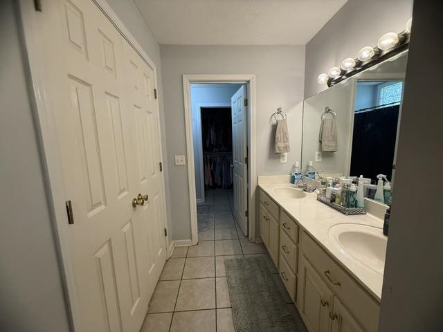 395 Austin Street Savannah, TN 38372 - Photo 12 of 32 Bathroom featuring a dual vanity with integrated sinks, a large wall-mounted mirror, and tile flooring