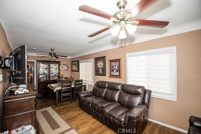 a living room with furniture ceiling fan and a window