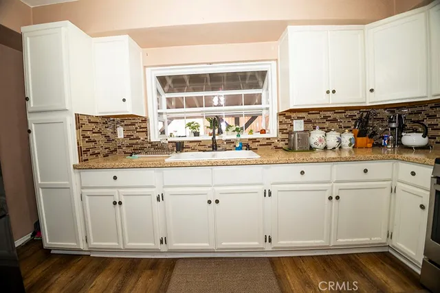 a kitchen with white cabinets and sink