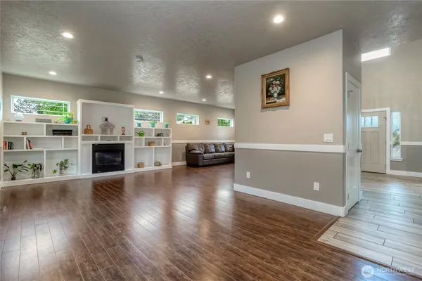 a view of a livingroom with furniture wooden floor fire place and windows