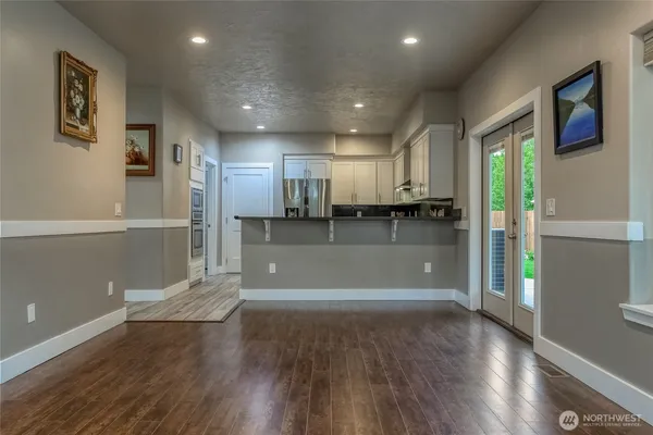 a kitchen with granite countertop a refrigerator sink and cabinets