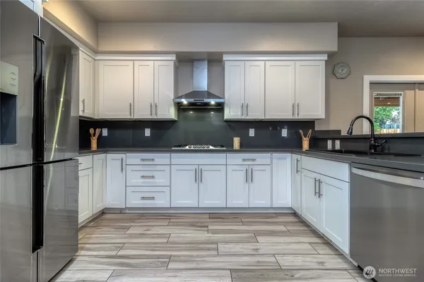 a kitchen with granite countertop white cabinets and a sink