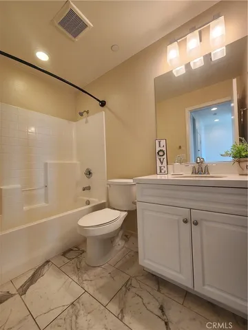 a bathroom with a toilet a sink a mirror a bathtub and vanity