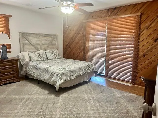 a bedroom with a bed lamp and a large window