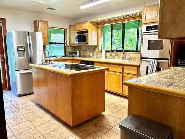 a kitchen with stainless steel appliances granite countertop a stove refrigerator sink and microwave