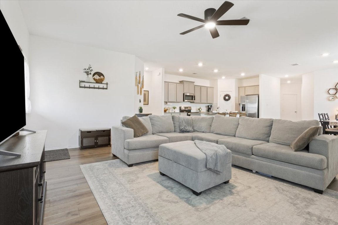 Living room with light wood-style flooring, recessed lighting, and a ceiling fan