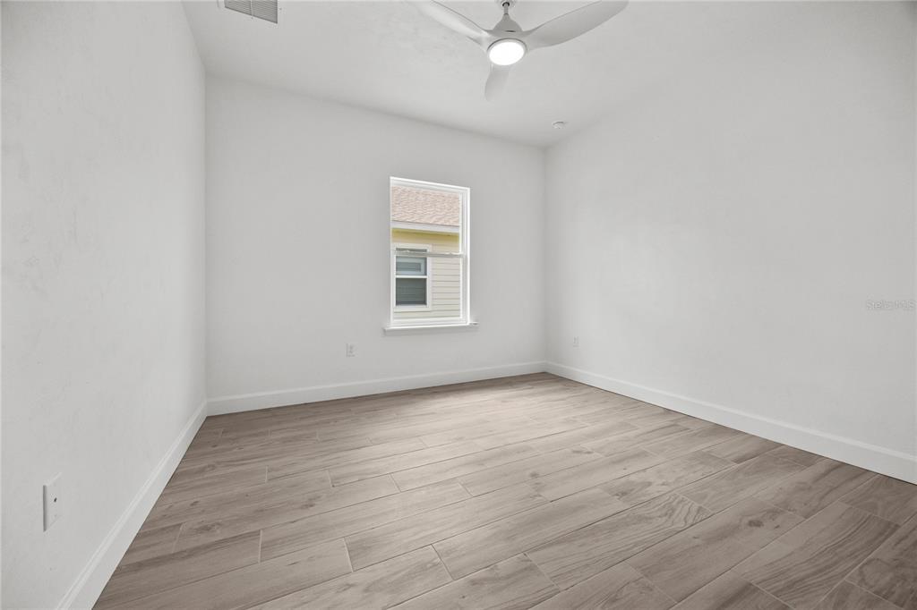 6702 Southwest 10th Lane Gainesville, FL 32607 - Photo 24 of 28 an empty room with wooden floor and windows