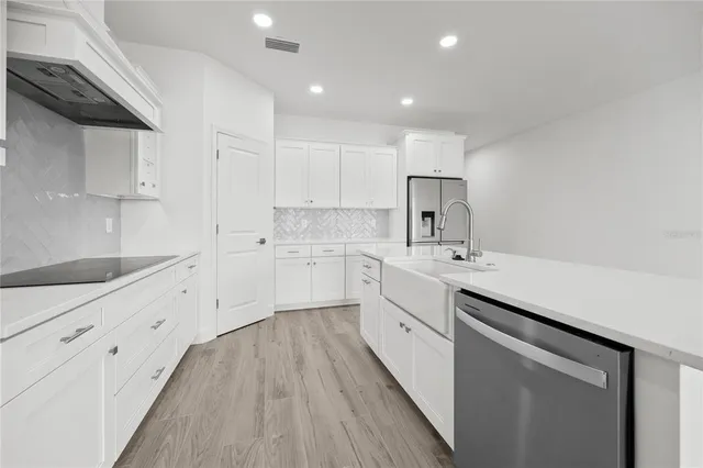 a kitchen with white cabinets and white appliances