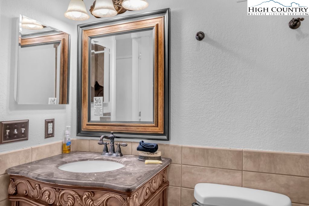 301 Pinnacle Inn Road, Unit 4314 Beech Mountain, NC 28604 - Photo 15 of 39 a bathroom with a granite countertop sink and a mirror