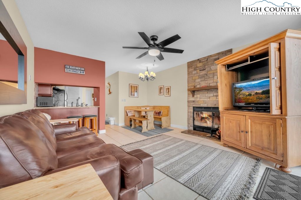 301 Pinnacle Inn Road, Unit 4314 Beech Mountain, NC 28604 - Photo 7 of 39 a living room with furniture a fireplace and a flat screen tv