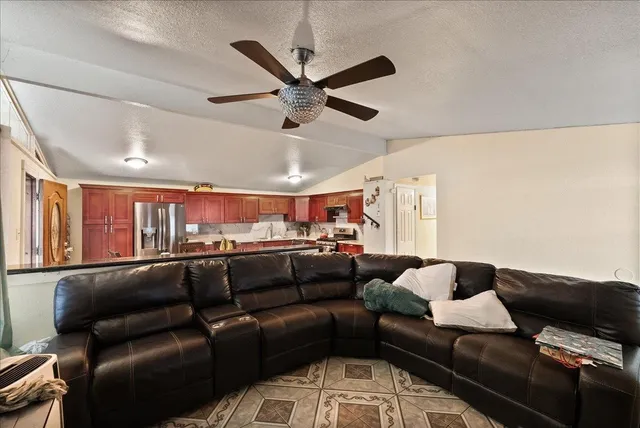 a living room with stainless steel appliances granite countertop furniture a couch and a view of kitchen