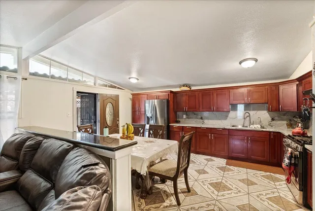 a kitchen with stainless steel appliances granite countertop a sink refrigerator and cabinets