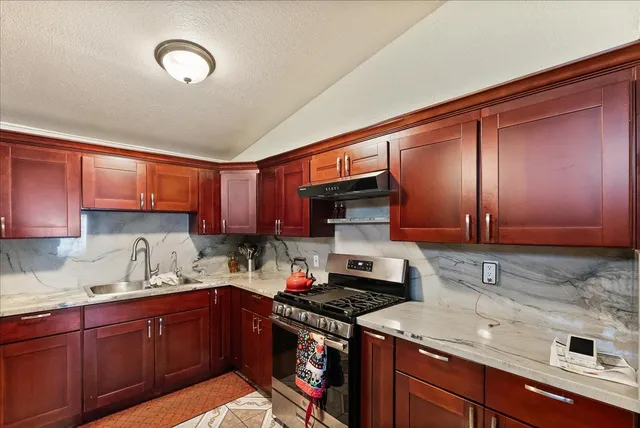 a kitchen with stainless steel appliances granite countertop a sink stove and cabinets