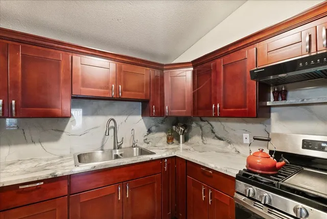 a open kitchen with stainless steel appliances kitchen island granite countertop a stove a sink a dining table and chairs