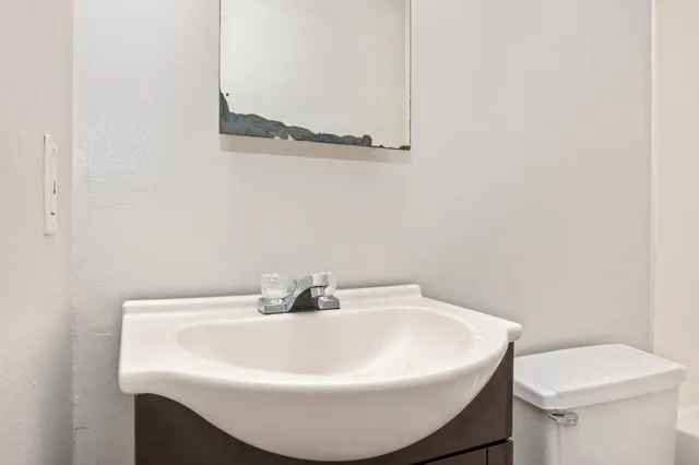 a white sink a toilet and a mirror