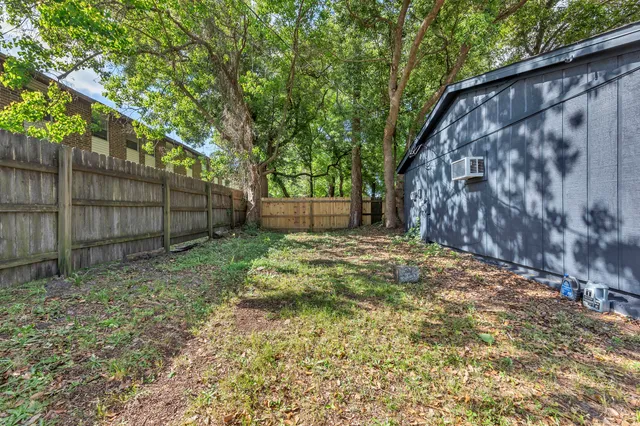 a backyard of a house with a small barn and wooden fence