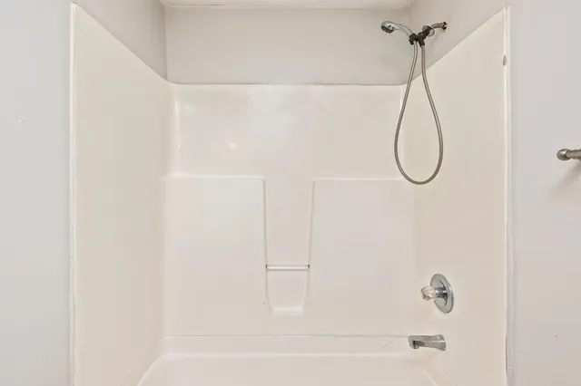 a bathroom with a bath tub with a shower