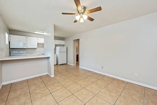 a view of kitchen with granite countertop cabinets and window