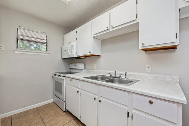 a kitchen with stainless steel appliances granite countertop a sink and a white cabinets