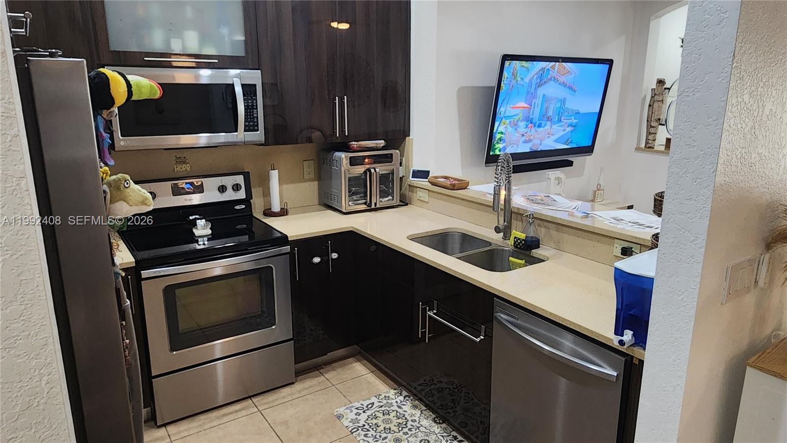 2607 Southwest 99th Way Miramar, FL 33025 - Photo 12 of 50 a kitchen with a sink stove and microwave