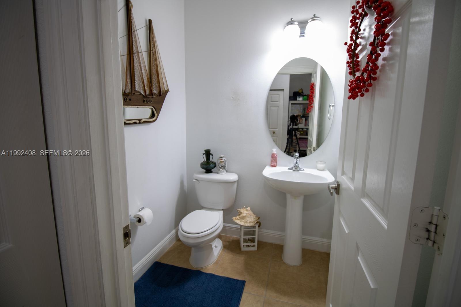 2607 Southwest 99th Way Miramar, FL 33025 - Photo 13 of 50 a bathroom with a toilet a sink and a mirror