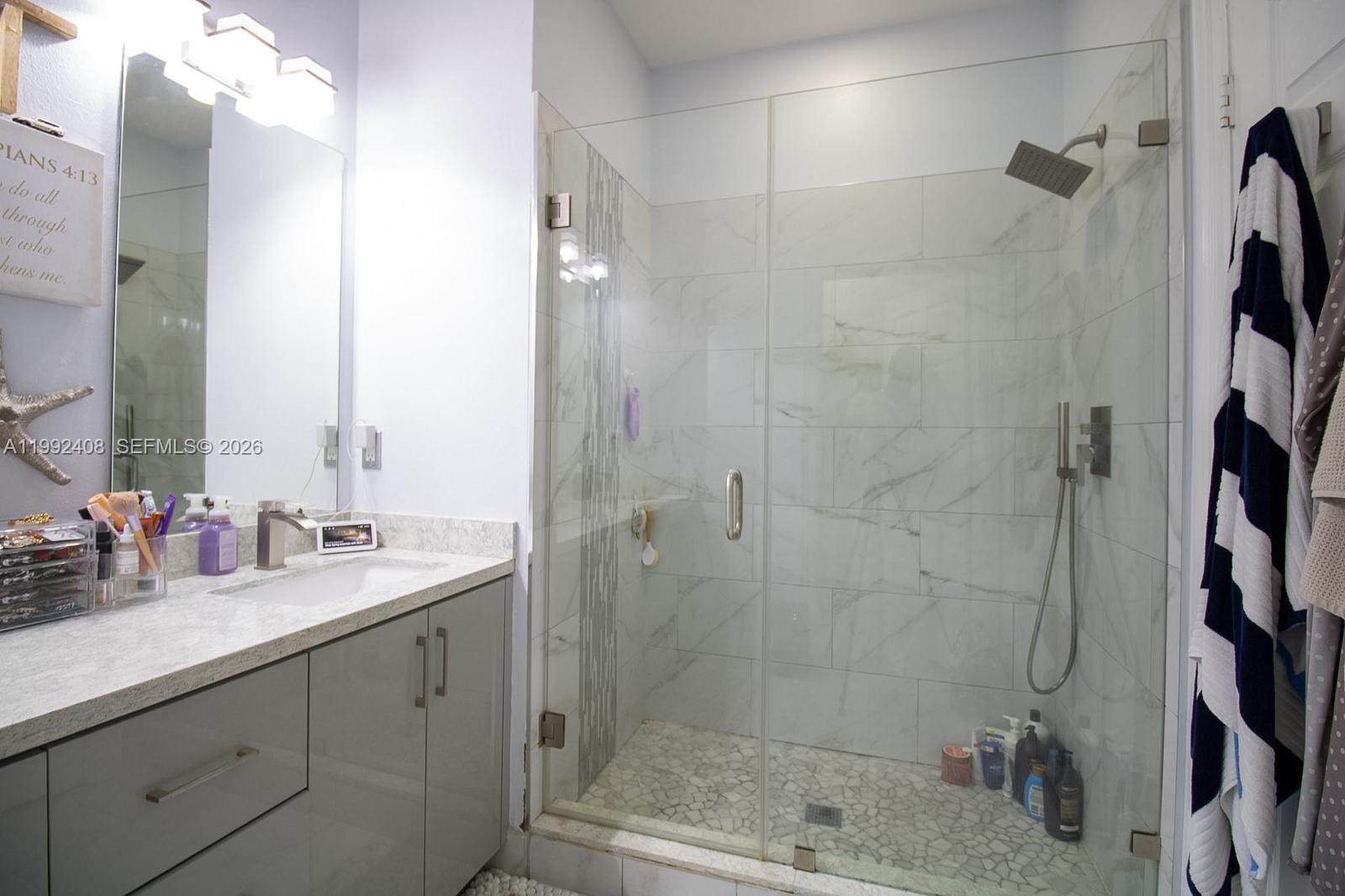 2607 Southwest 99th Way Miramar, FL 33025 - Photo 31 of 50 a bathroom with a shower sink and mirror