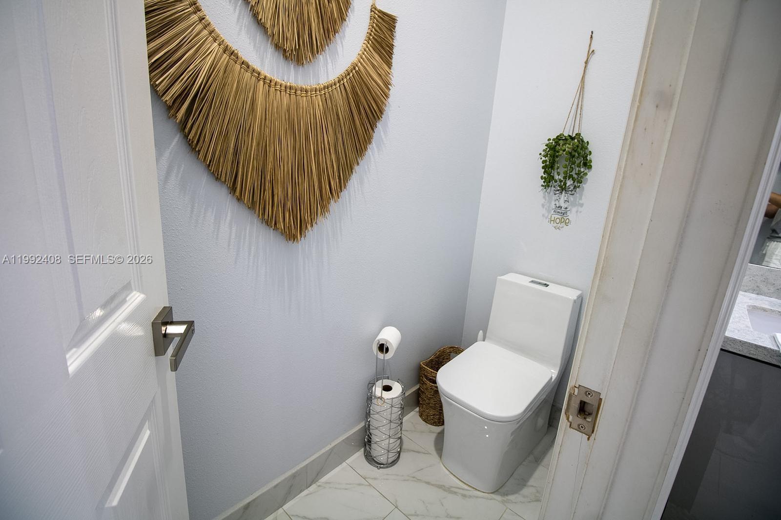 2607 Southwest 99th Way Miramar, FL 33025 - Photo 33 of 50 a bathroom with a toilet and a potted plant