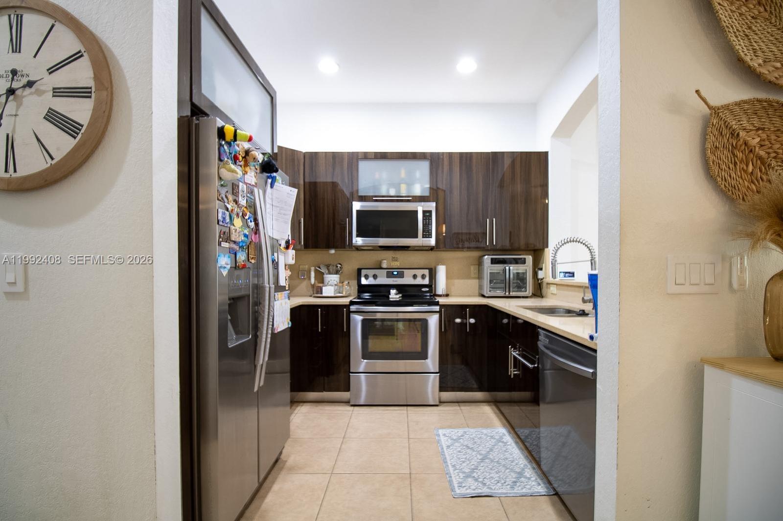 2607 Southwest 99th Way Miramar, FL 33025 - Photo 10 of 50 a kitchen with stainless steel appliances granite countertop a refrigerator and a stove top oven