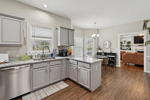 a kitchen with a sink cabinets and wooden floor