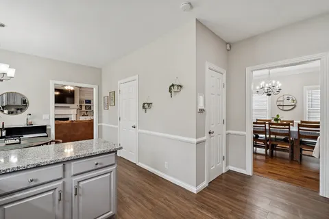 a living room with stainless steel appliances kitchen island granite countertop furniture and wooden floor