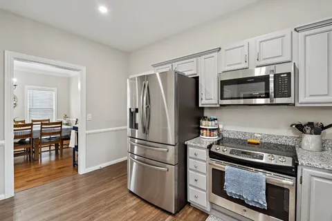 a kitchen with stainless steel appliances granite countertop a stove a refrigerator and a microwave