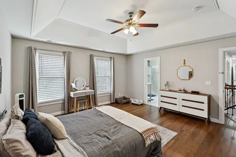 a bedroom with a bed ceiling fan and window