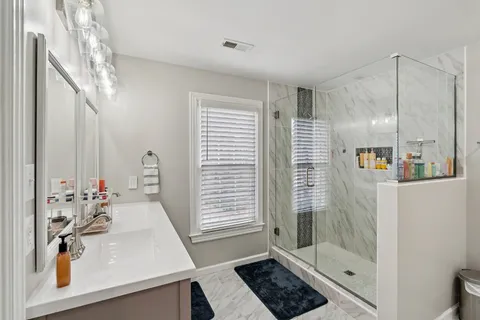 a bathroom with a sink a toilet and shower