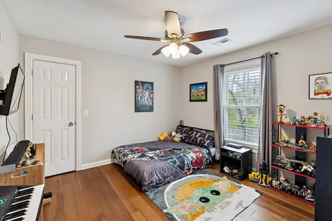 a bedroom with bed and wooden floor