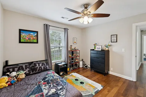a bedroom with a bed and wooden floor