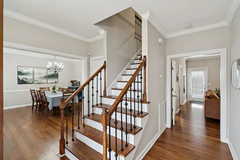 a view of a hallway with wooden floor and stairs