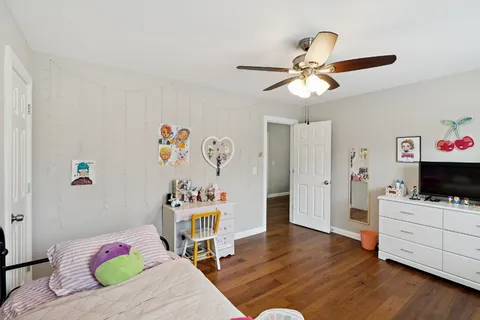 a bedroom with a bed and wooden floor