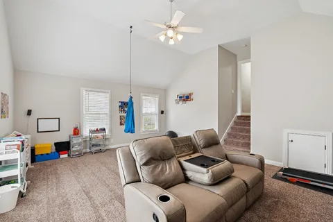 a living room with furniture a ceiling fan and a window