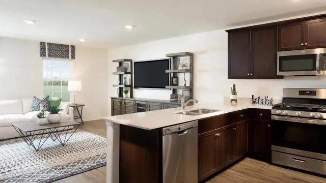 a kitchen with stainless steel appliances a sink dishwasher a stove top oven a refrigerator with island and chairs