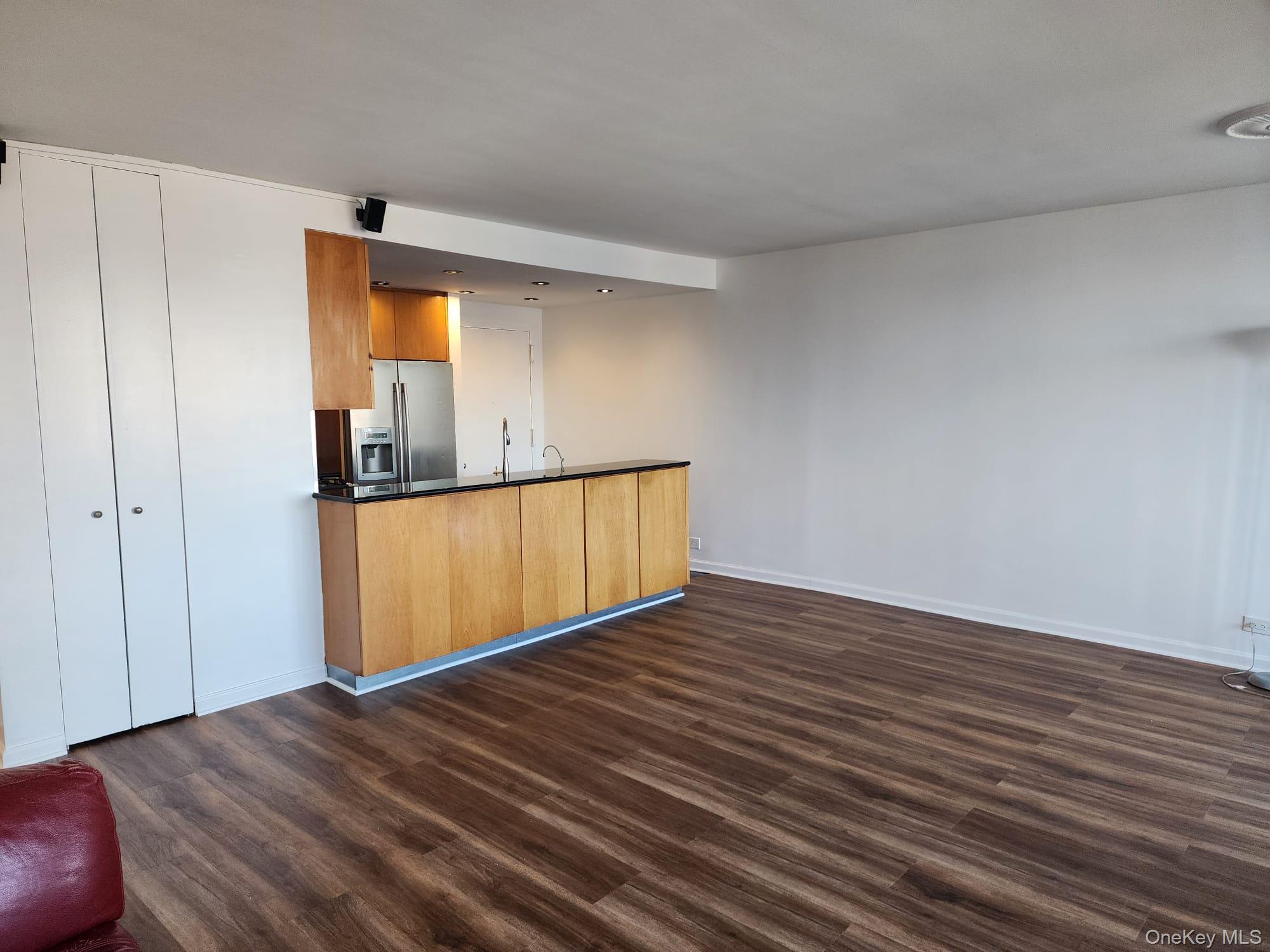 62-54 97th Place, Unit 12J Queens, NY 11374 - Photo 11 of 12 Kitchen featuring open floor plan, brown cabinets, a peninsula, and dark countertops