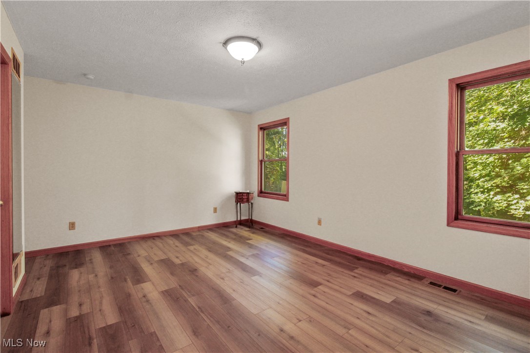 2632 Berry Road Akron, OH 44320 - Photo 21 of 39 Spare room with light wood-type flooring, a textured ceiling, and plenty of natural light
