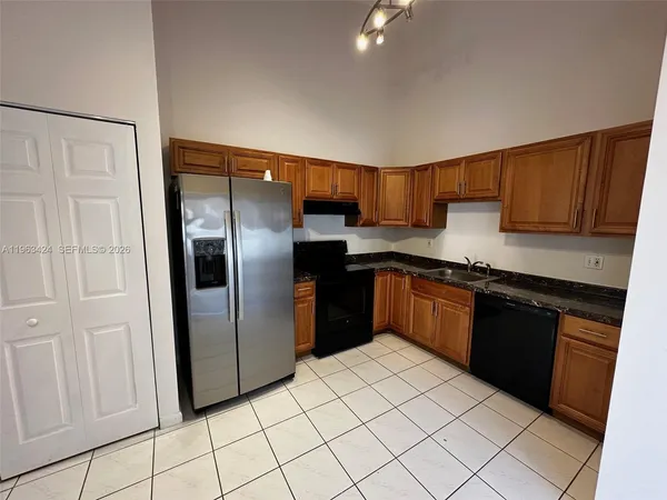 a kitchen with stainless steel appliances granite countertop a refrigerator and a stove top oven