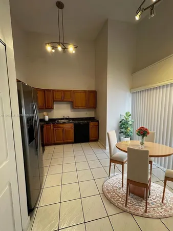 a kitchen with granite countertop a table and chairs in it