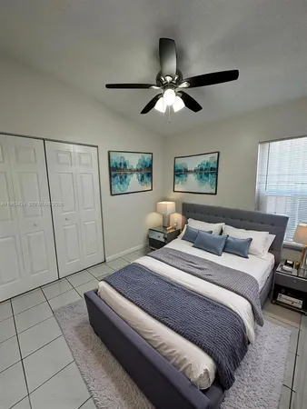 a spacious bedroom with a bed and a chandelier