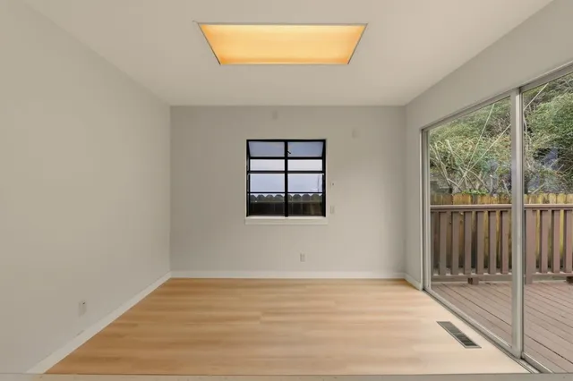 a kitchen with stainless steel appliances granite countertop a stove a sink and white cabinets with wooden floors