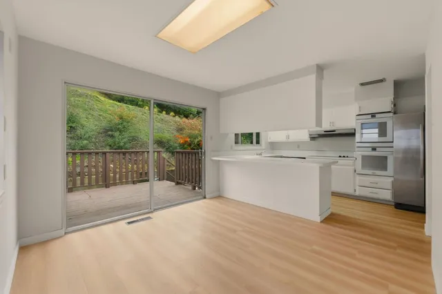 a kitchen with white cabinets and a refrigerator
