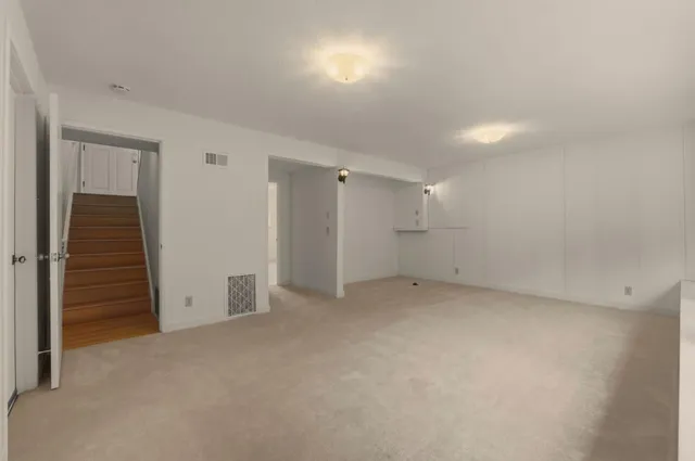 a bedroom with bed a couch and potted plant