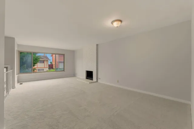 a living room with a fireplace and large windows