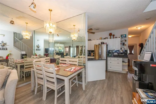 a dining room with stainless steel appliances kitchen island granite countertop a table chairs and a dining table view