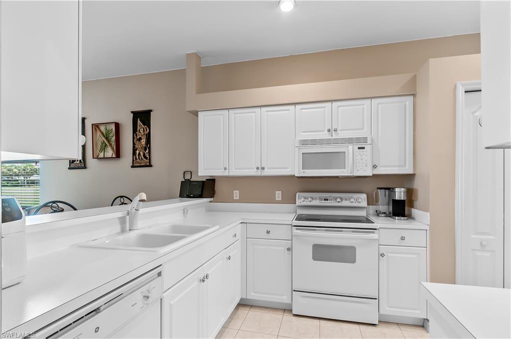 21520 Portrush Run Estero, FL 33928 - Photo 8 of 34 a kitchen with cabinets appliances a sink and a counter top space
